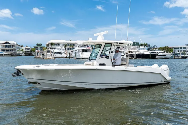  Yacht Photos Pics 2020 Boston Whaler 280 Outrage boat cruising in a marina under a clear blue sky.