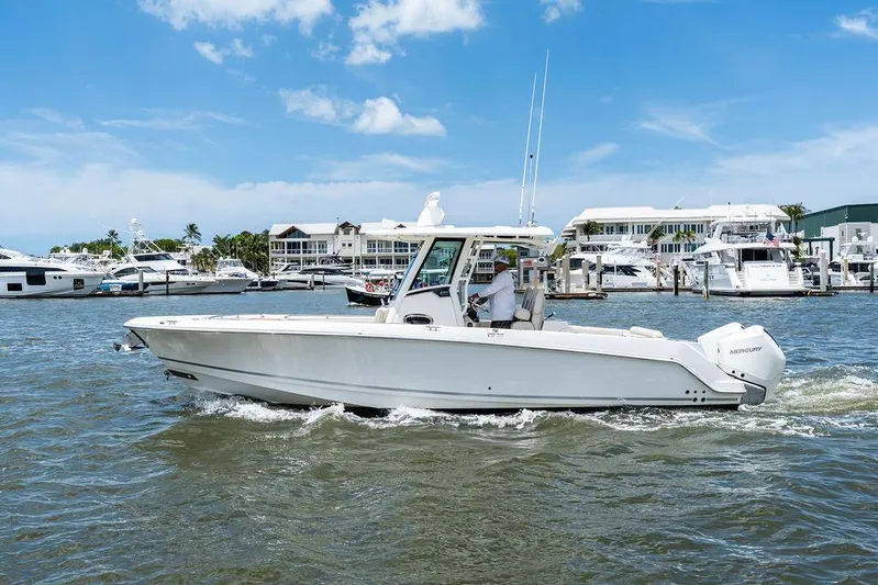  Yacht Photos Pics 2020 Boston Whaler 280 Outrage boat cruising in a marina under a clear blue sky.