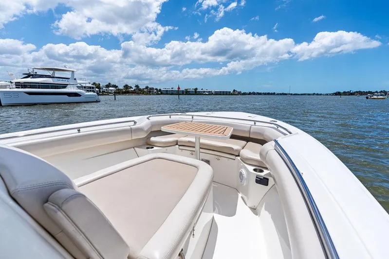  Yacht Photos Pics 2020 Boston Whaler 280 Outrage boat interior with seating and table on a sunny day.