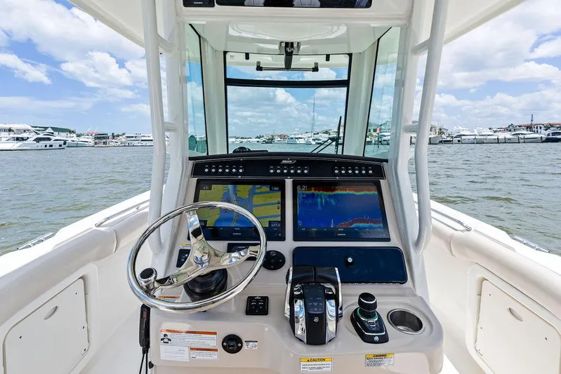  Yacht Photos Pics Boston Whaler 280 Outrage 2020 helm with advanced navigation system on open water.