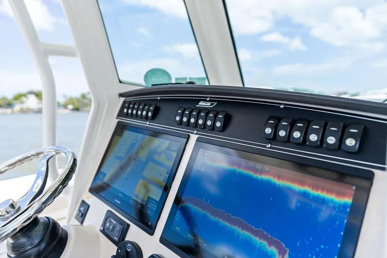  Yacht Photos Pics Control panel of 2020 Boston Whaler 280 Outrage with navigation screens and buttons.