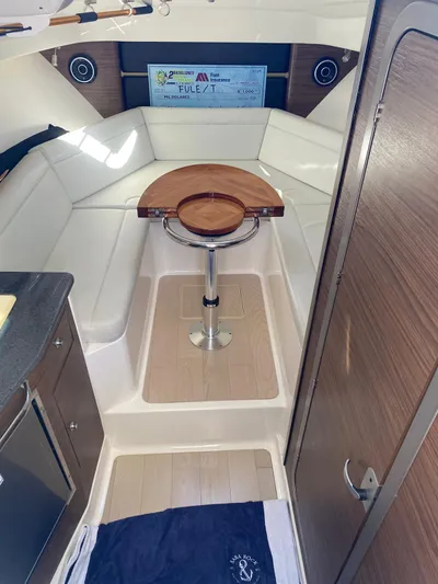  Yacht Photos Pics 2021 Boston Whaler 325 Conquest cabin interior with seating and wooden table.