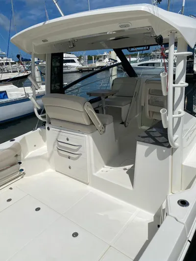  Yacht Photos Pics 2021 Boston Whaler 325 Conquest boat interior at marina, featuring seating and storage.
