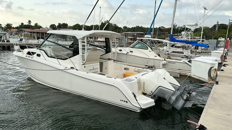  Yacht Photos Pics 2021 Boston Whaler 325 Conquest docked at marina, showcasing sleek design and powerful engines.