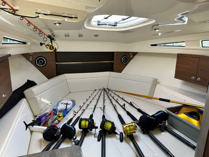  Yacht Photos Pics 2021 Boston Whaler 325 Conquest cabin with fishing rods and gear neatly arranged.