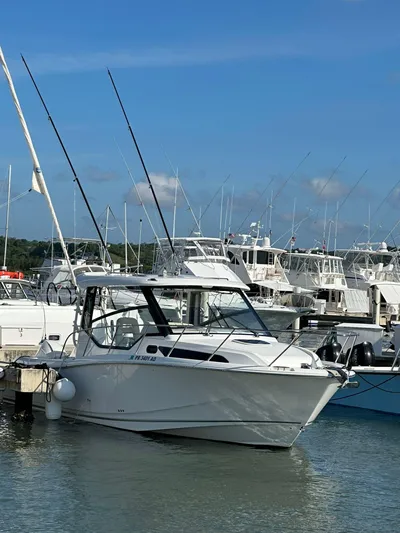  Yacht Photos Pics 2021 Boston Whaler 325 Conquest docked in a marina under a clear blue sky.