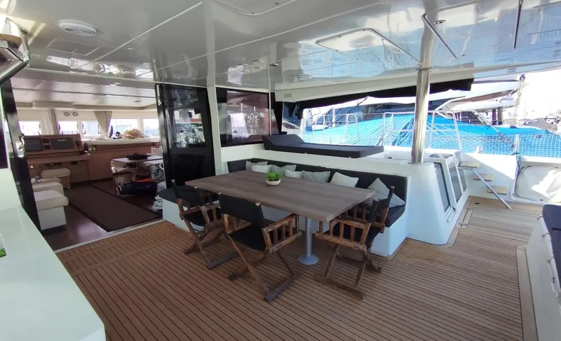 Jarana Yacht Photos Pics Luxurious Lagoon 620 yacht interior, featuring a spacious dining area with wooden flooring, 2012 model.