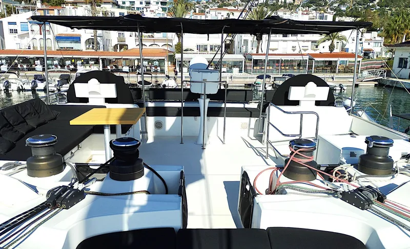 Jarana Yacht Photos Pics 2012 Lagoon 620 yacht deck with seating, table, and marina view.