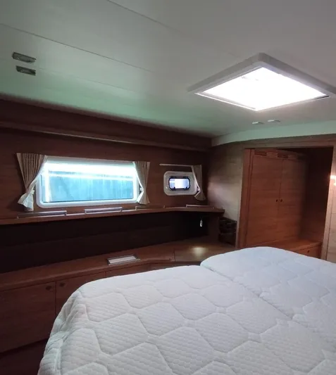 Jarana Yacht Photos Pics Luxurious cabin interior of 2012 Lagoon 620 yacht with cozy bed and wooden furnishings.