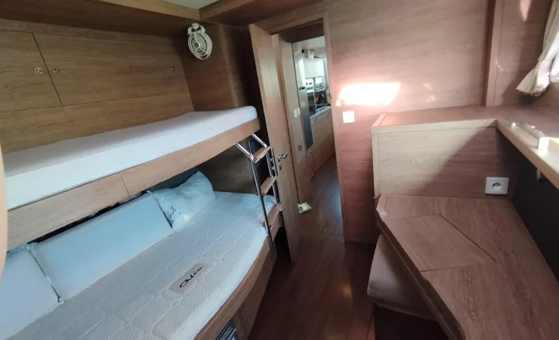 Jarana Yacht Photos Pics 2012 Lagoon 620 yacht interior with wooden bunk beds and desk area.