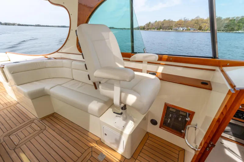 Just B Yacht Photos Pics 2018 Hinckley Picnic Boat MKII interior with white seating and wooden flooring.