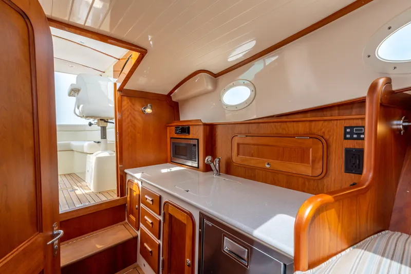 Just B Yacht Photos Pics 2018 Hinckley Picnic Boat MKII interior with wooden cabinetry and modern amenities.