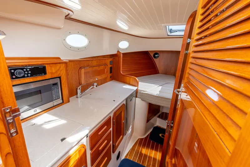 Just B Yacht Photos Pics 2018 Hinckley Picnic Boat MKII interior with kitchenette and cozy sleeping area.