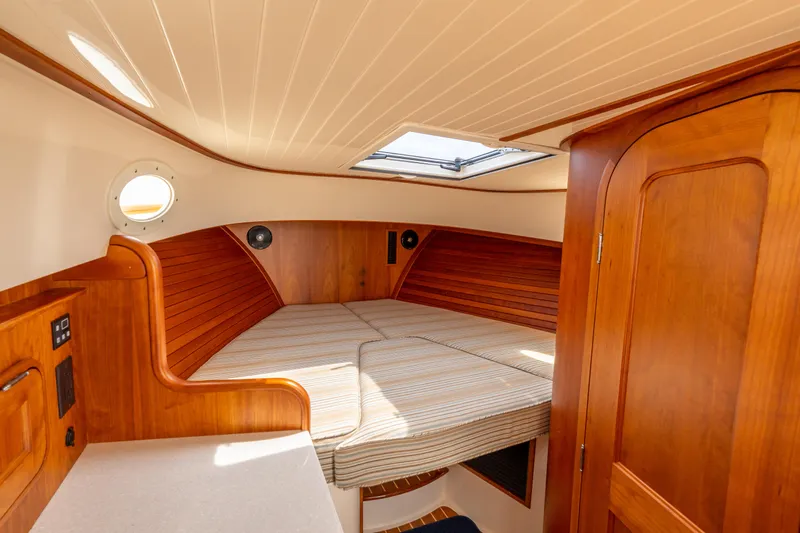 Just B Yacht Photos Pics 2018 Hinckley Picnic Boat MKII cabin interior with wood finish and cozy bed.