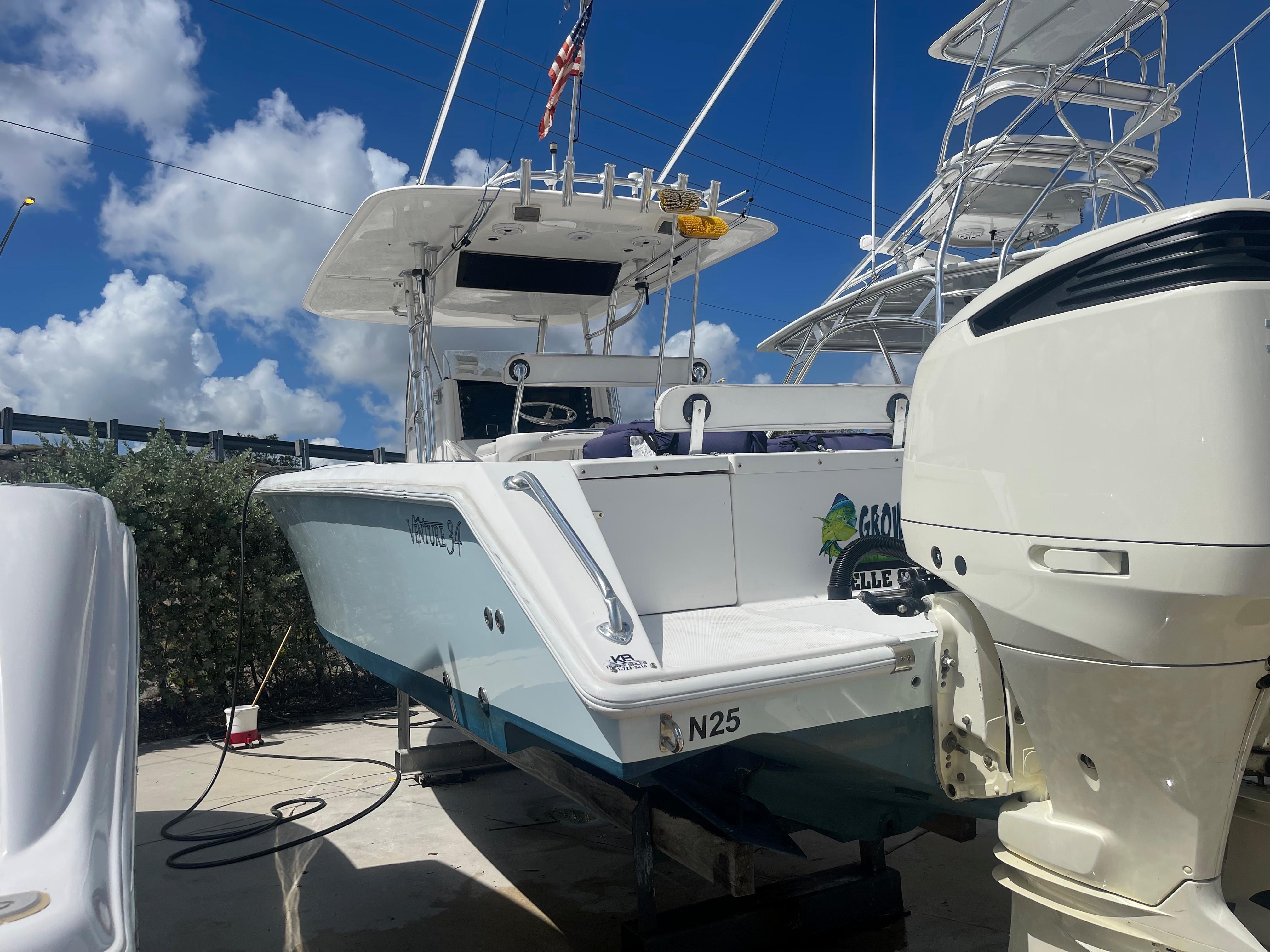 2004 Venture 34 Open boat docked, featuring a sleek design and powerful outboard motor.
