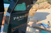 Pardo Yachts 43, 2020 model, sleek design with luxury seating, docked near rocky shoreline.