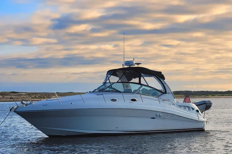  Yacht Photos Pics 2004 Sea Ray 340 Sundancer yacht on calm water at sunset.