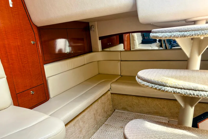  Yacht Photos Pics Luxurious interior of 2004 Sea Ray 340 Sundancer yacht with beige seating and wooden cabinetry.