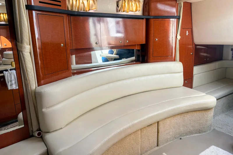  Yacht Photos Pics Luxurious interior of 2004 Sea Ray 340 Sundancer with curved leather seating and wooden cabinetry.