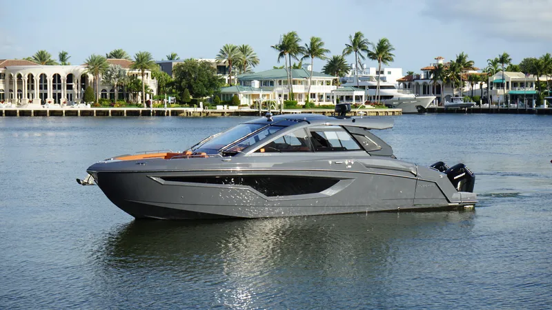Lazy Blum Yacht Photos Pics 2023 Cruisers Yachts 42 GLS OB on calm water, luxury waterfront homes in background.