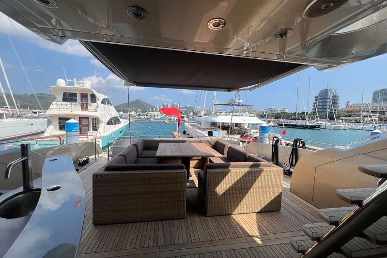  Yacht Photos Pics Luxurious Sunseeker Predator 108 yacht deck with seating, docked in a scenic marina.
