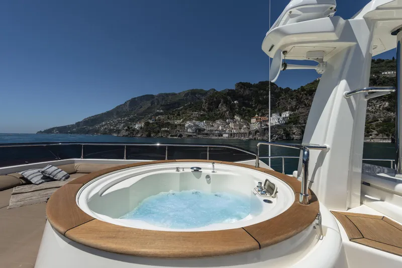  Yacht Photos Pics Luxurious 2013 Custom Line Navetta 33 Crescendo yacht with jacuzzi, scenic coastal backdrop.