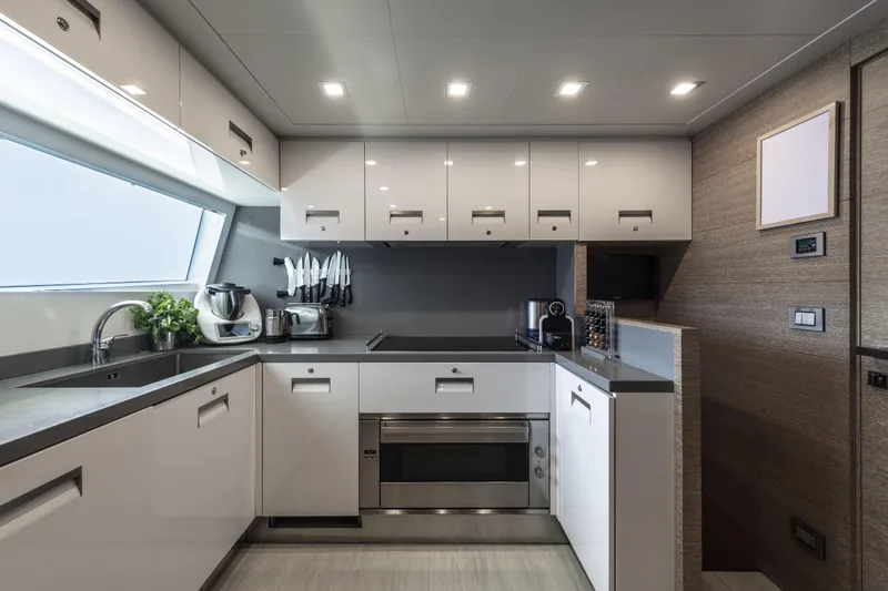  Yacht Photos Pics Modern yacht kitchen interior on 2013 Custom Line Navetta 33 Crescendo, featuring sleek cabinetry and appliances.
