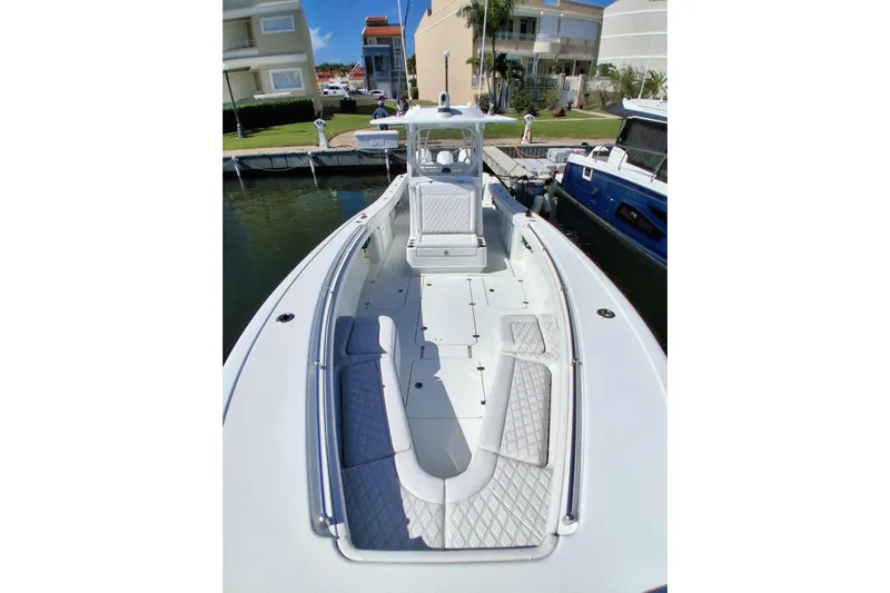 Testa Dura Yacht Photos Pics 2023 Yellowfin 36 Offshore boat docked, showcasing spacious deck and seating.