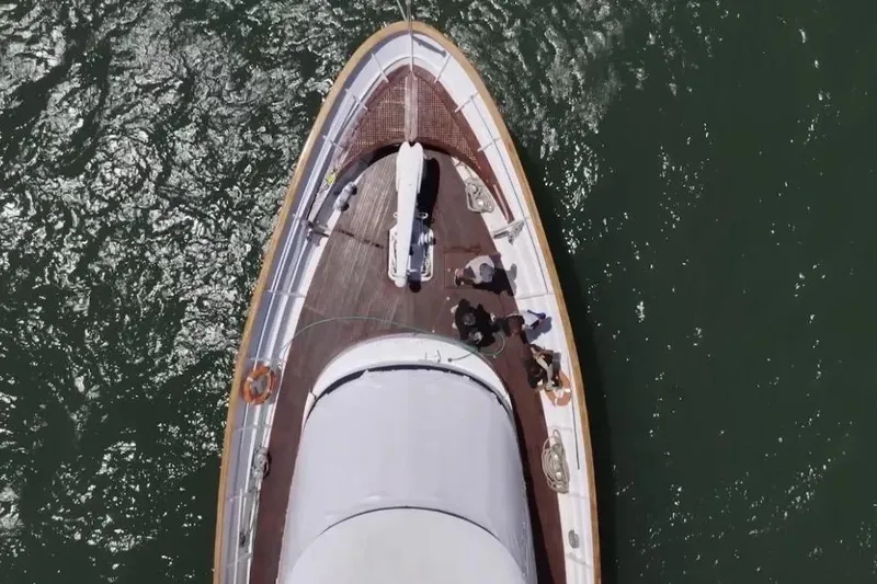  Yacht Photos Pics Aerial view of 1987 Lurssen 110 yacht on water, showcasing deck and bow.