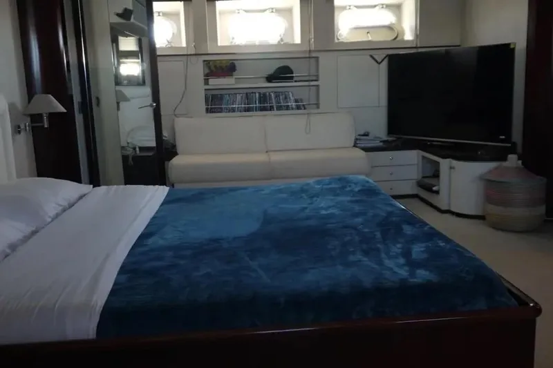  Yacht Photos Pics Luxurious bedroom interior on 1987 Lurssen 110 yacht, featuring a cozy bed and entertainment area.