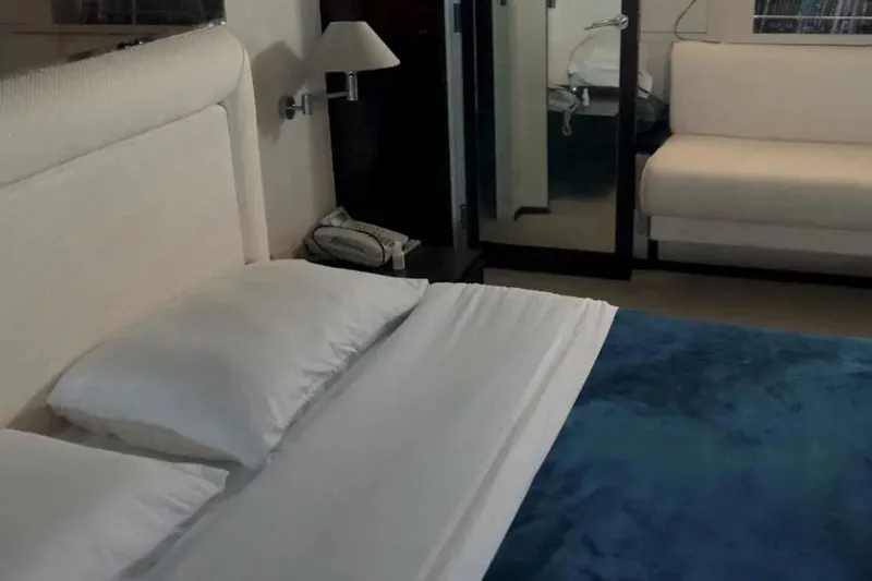  Yacht Photos Pics Luxurious bedroom interior on 1987 Lurssen 110 yacht, featuring elegant bedding and modern decor.