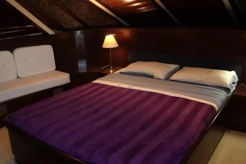  Yacht Photos Pics Luxurious bedroom interior on 1987 Lurssen 110 yacht with cozy lighting and elegant decor.