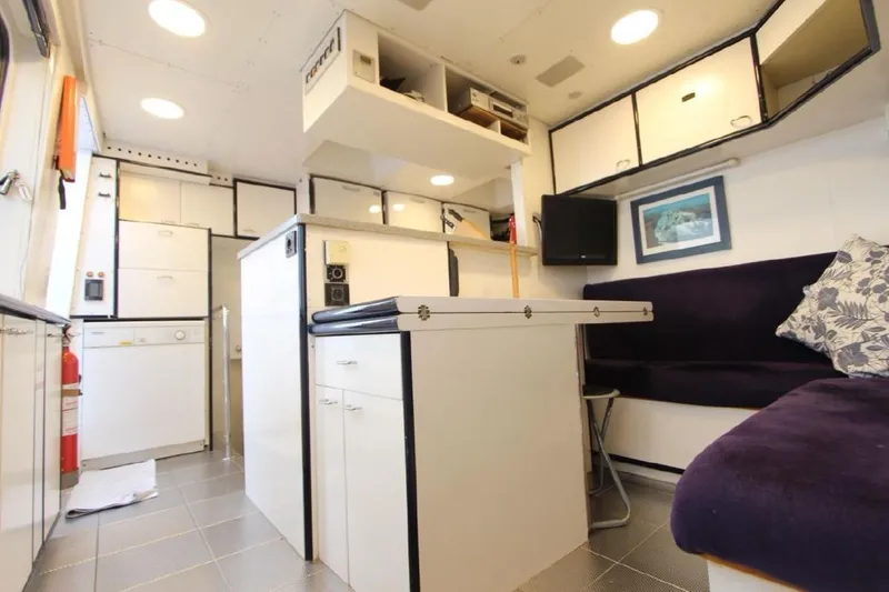  Yacht Photos Pics Interior of 1987 Lurssen 110 yacht, featuring modern kitchen and cozy seating area.