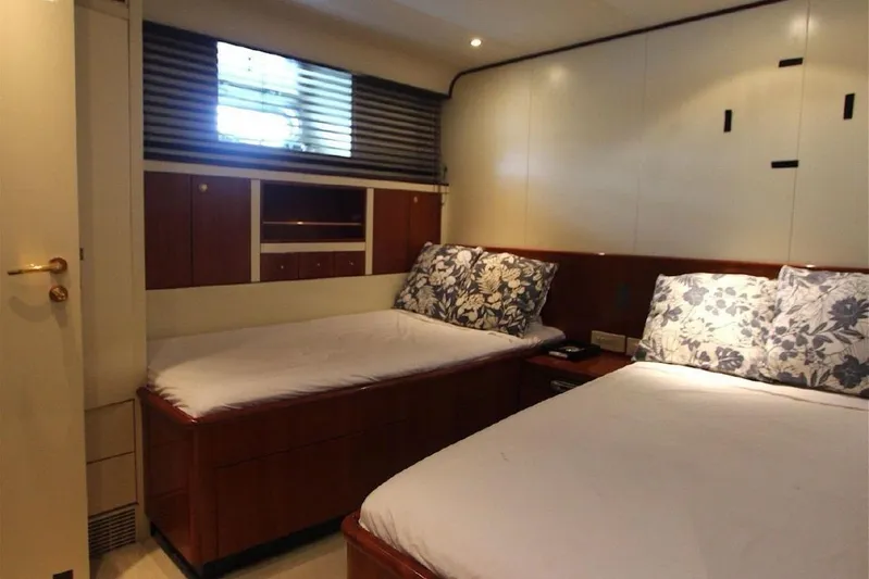  Yacht Photos Pics Cozy twin bedroom on 1987 Lurssen 110 yacht with floral pillows and wooden accents.