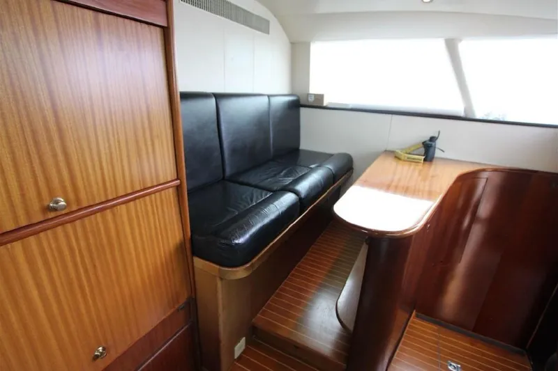  Yacht Photos Pics Interior of 1987 Lurssen 110 yacht with black leather seating and wooden finishes.