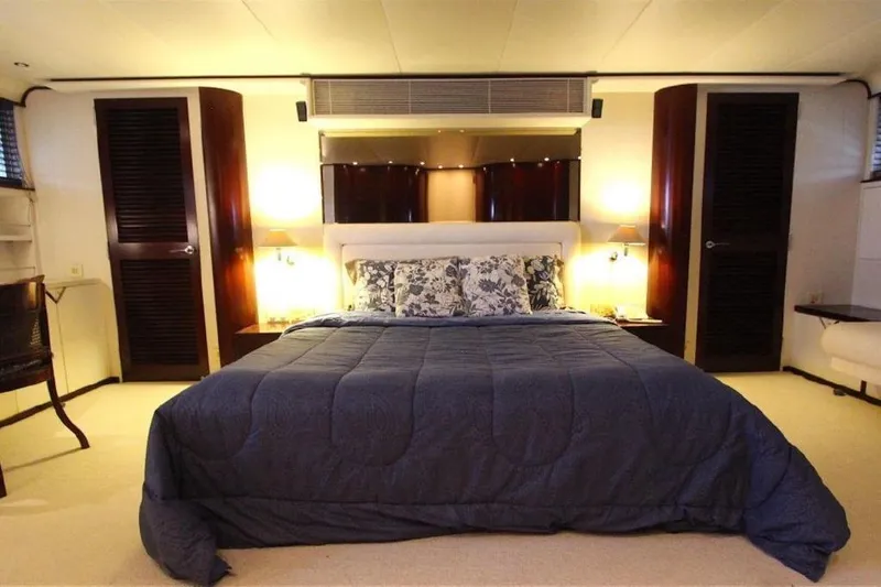  Yacht Photos Pics Luxurious bedroom interior on 1987 Lurssen 110 yacht, featuring elegant bedding and ambient lighting.