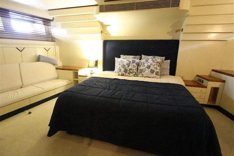  Yacht Photos Pics Luxurious bedroom interior on 1987 Lurssen 110 yacht with cozy bed and elegant decor.