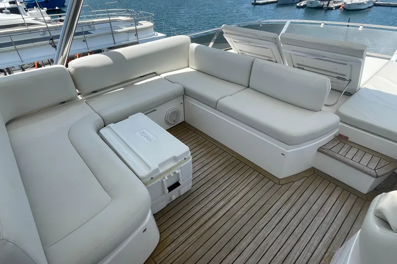 Sea C Yacht Photos Pics Luxurious Sunseeker 73 yacht deck with white seating, wooden flooring, and scenic marina view.