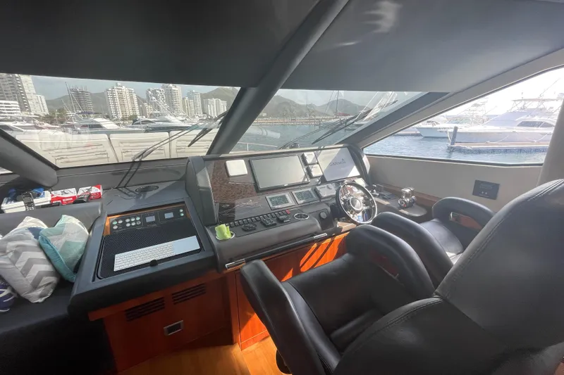 Sea C Yacht Photos Pics Interior view of 2012 Sunseeker 73 yacht cockpit with modern controls and cityscape background.