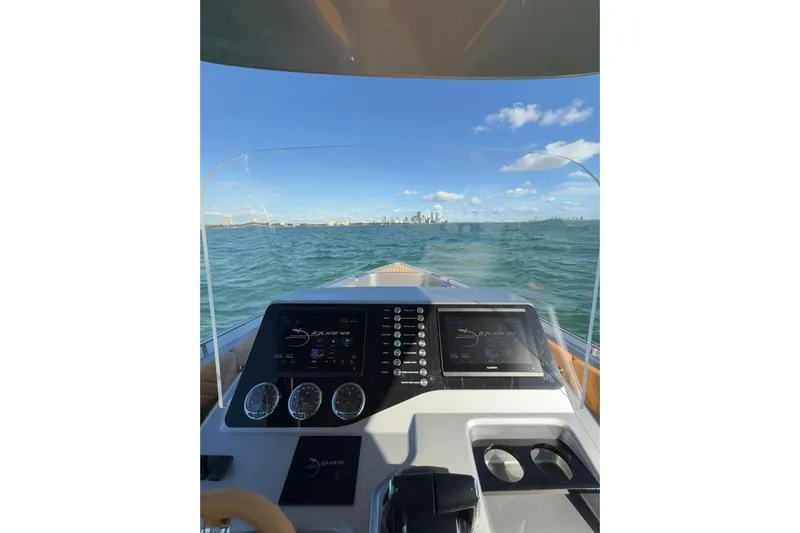 Iguana Sport Exclusive Yacht Photos Pics Cockpit view of 2025 Iguana Yacht Sport Exclusive on open water, city skyline ahead.