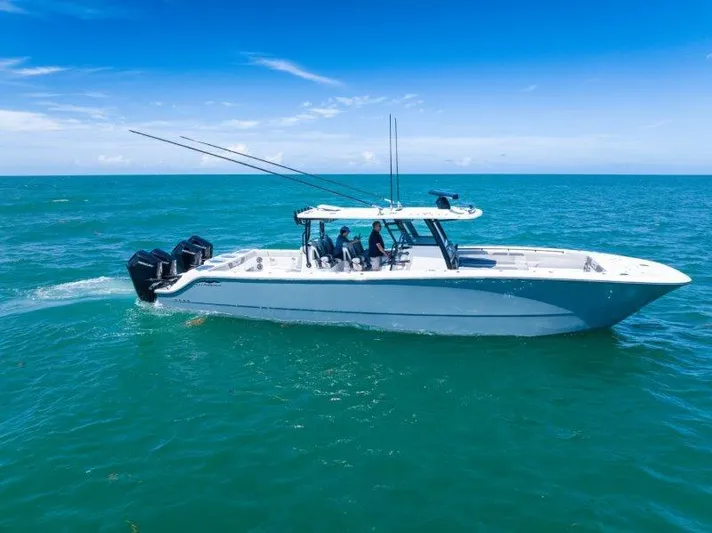  Yacht Photos Pics 2025 Invincible 46 Catamaran cruising on clear blue ocean waters.