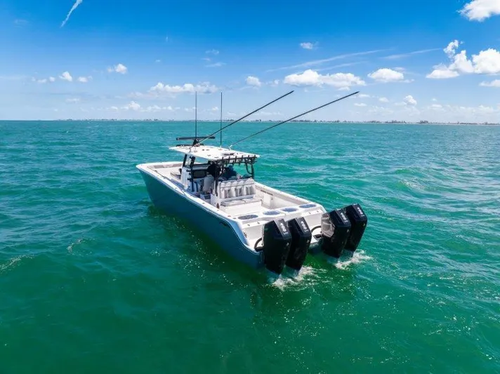  Yacht Photos Pics 2025 Invincible 46 Catamaran cruising on clear blue ocean under sunny skies.