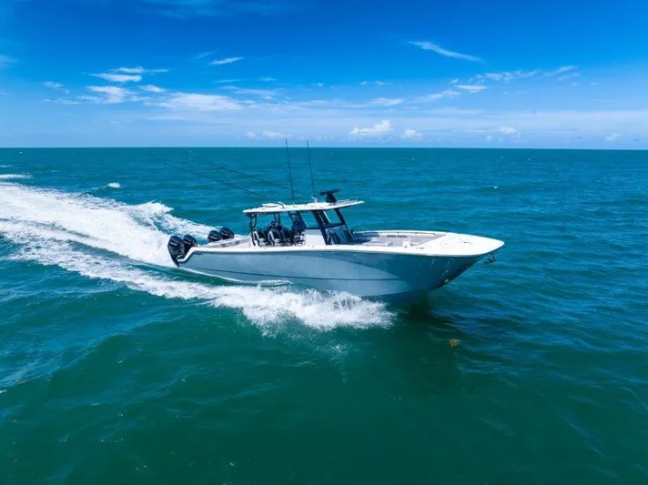  Yacht Photos Pics 2025 Invincible 46 Catamaran cruising on open ocean under clear blue sky.