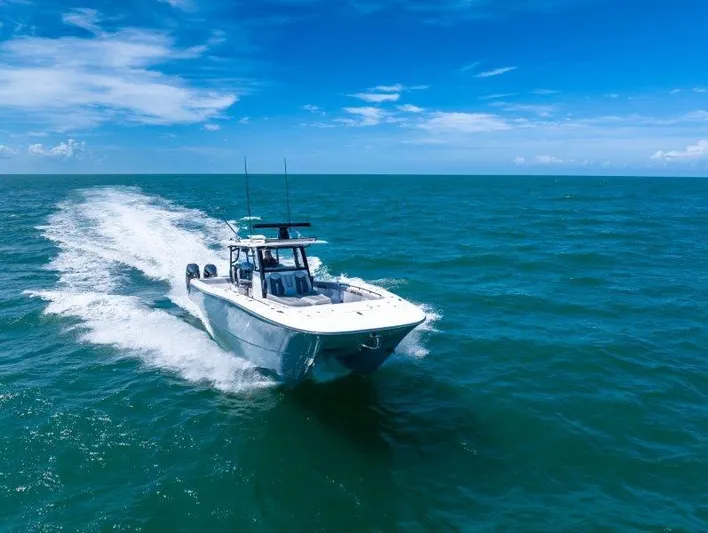  Yacht Photos Pics 2025 Invincible 46 Catamaran cruising on open ocean under clear blue sky.