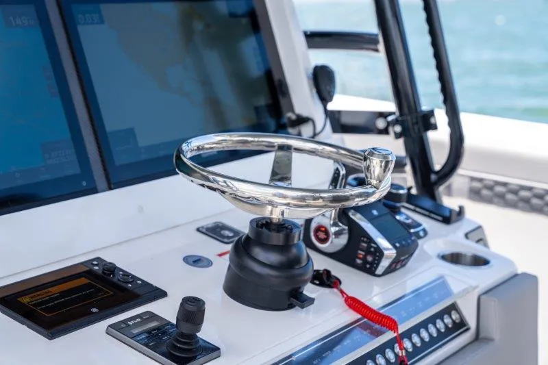  Yacht Photos Pics Control panel of 2025 Invincible 46 Catamaran with steering wheel and navigation screens.