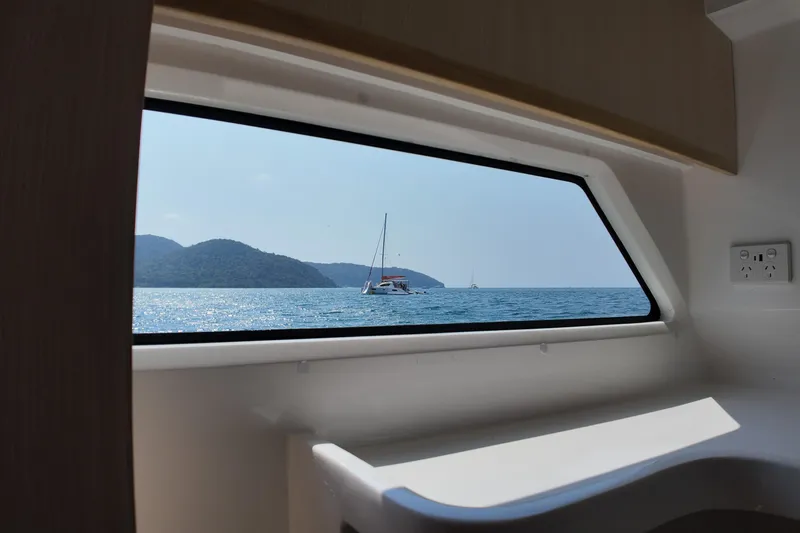  Yacht Photos Pics Interior view from Longreach 58 yacht, showcasing ocean and distant sailboat through window.