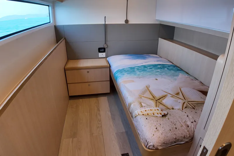  Yacht Photos Pics Cozy cabin interior of 2026 Longreach 58 yacht with beach-themed bedding.