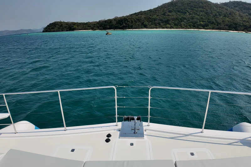  Yacht Photos Pics Deck view from 2026 Longreach 58 yacht overlooking serene ocean and lush island.