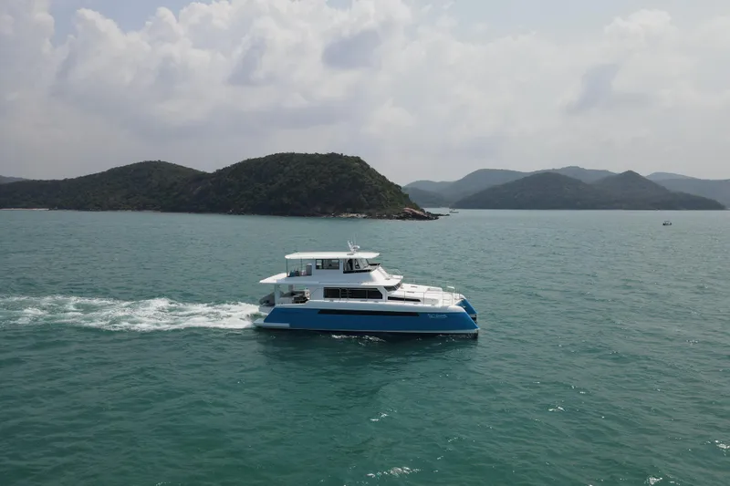  Yacht Photos Pics Luxury Longreach 58 yacht cruising in scenic waters, 2026 model, with lush islands in the background.