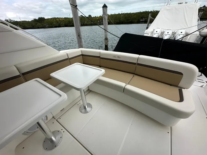  Yacht Photos Pics 2010 Sea Ray 470 Sundancer yacht with outdoor seating and tables by the water.